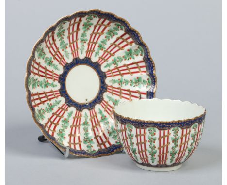 A Worcester fluted tea bowl and saucer. Decorated in coloured enamels and gilt with the hop trellis pattern c1780. Saucer 12.