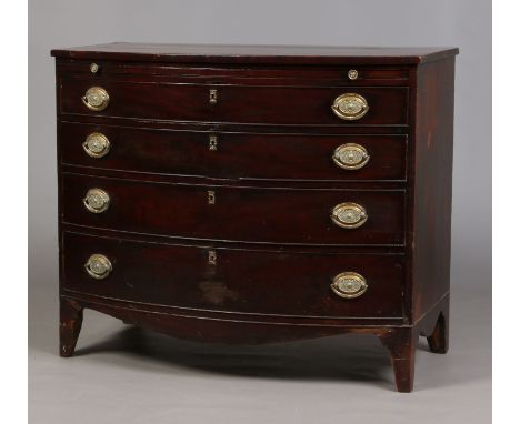 A Georgian mahogany bowfront bachelors chest of four graduated drawers incorporating a brushing slide and raised on bracket f