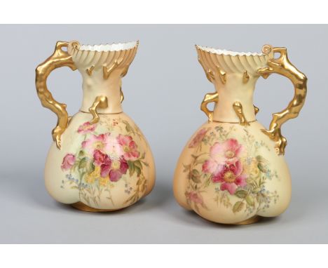 A pair of Royal Worcester blush ware lobed ewers. With naturalistic coral moulded handles decorated in gilt and painted with 