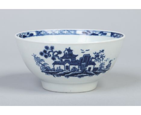 A small Worcester bowl printed in underglaze blue with an early version of the plantation pattern and with a handpainted inte