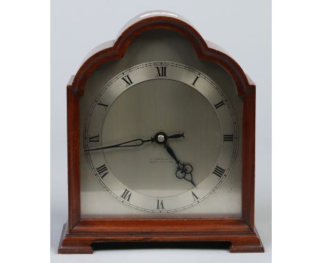 A mahogany cased dome top mantel clock raised on ogee bracket feet. With silvered dial and housing a cylinder movement with p