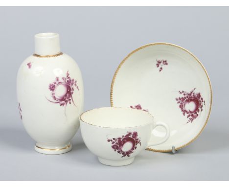 A Worcester ovoid tea canister and matching teacup and saucer. With gilt dentil rims and decorated in puce camaieu with fruit