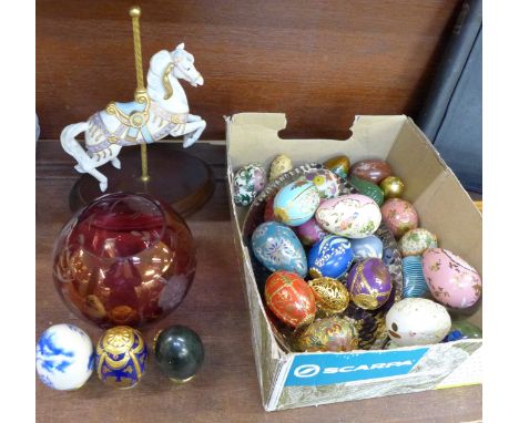 A collection of Thailand and other decorative eggs in a tray, a cranberry glass bowl and a Franklin Mint Carousel Magic horse