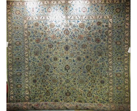 KASHAN CARPET, 415cm x 320cm, all over scrolling palmette and vine design on a jade field within ivory guard stripes and a re