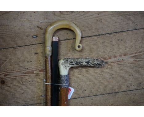 A 9ct gold mounted ebonized cane;&nbsp;together with another silver mounted antler handled malacca cane; and another shepherd