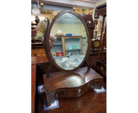 A good George III mahogany and chequer strung serpentine fronted oval toilet mirror,&nbsp;43.5cm wide. 