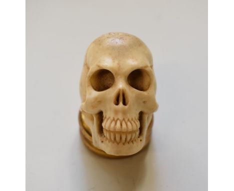 A Japanese carved bone memento mori skull netsuke, 4.5cm high. 
