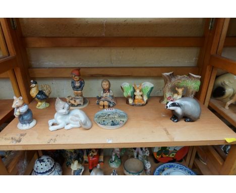 A small collection of pottery and porcelain figures, to include: a Royal Doulton Badger HN2666; a Lladro Cat; two Hummel figu
