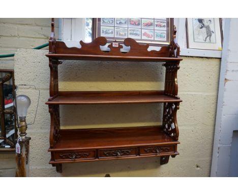A reproduction mahogany hanging three tier open shelf, with fretwork sides, 86 x 67cm, (s.d.). 