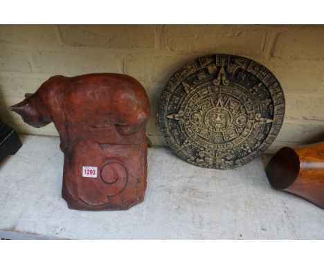 A composition stone cat roof ridge tile,&nbsp;25cm high; together with a similar Aztec wall plaque, 29.5cm diameter. (2) 