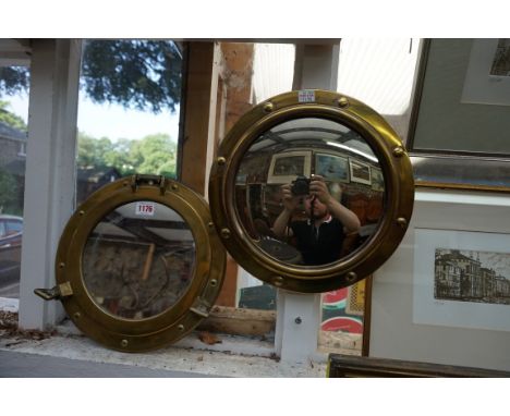 A brass framed porthole style wall mirror, 29.5cm diameter; together with another similar convex wall mirror, (formally elect