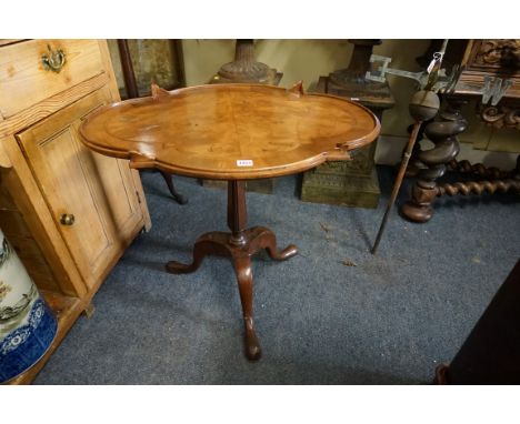 An old walnut and mahogany tilt-top tripod table, of shaped outline, 75cm wide, (repair to one leg). 