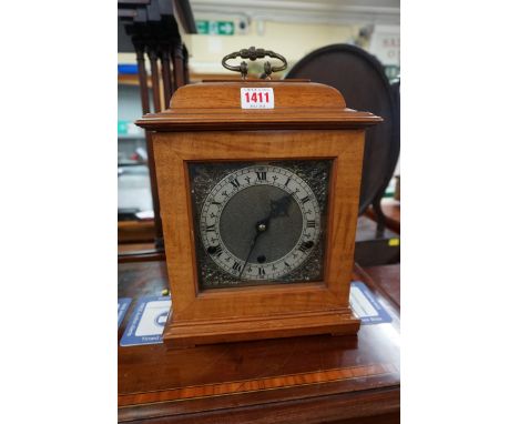 A reproduction walnut mantel clock, striking on gongs, height including handle 31.5cm, with pendulum. 