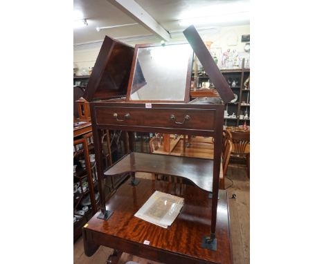 An early 19th century mahogany gentleman's wash stand,&nbsp;the hinged top opening to reveal a ratcheted mirror flanked by li