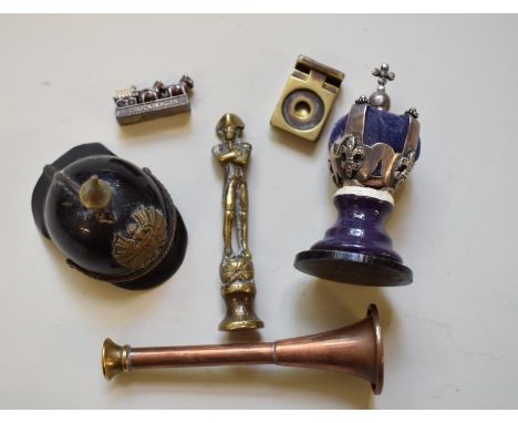 A mixed group of objects, to include: a brass Nelson pipe tamper; a small model of a pickelhaube helmet; a similar model crow