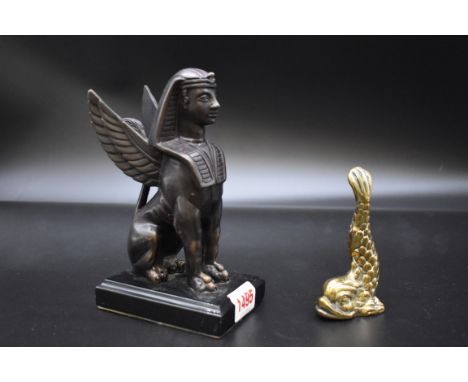 A bronze sphinx,&nbsp;on slate base, 17.5cm high; together with a small brass dolphin paperweight, inscribed 'Malta', 10.5cm 