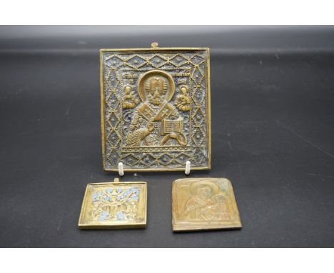 A Russian bronze icon of St Nicholas,&nbsp;11 x 10cm; together with two further smaller examples. (3) 