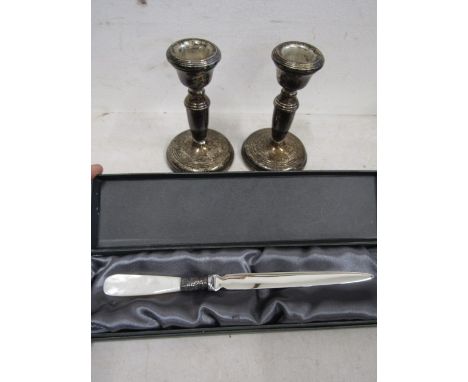 Silver hallmarked candlesticks (weighted) and a mother of pearl silver collared knife&nbsp;
