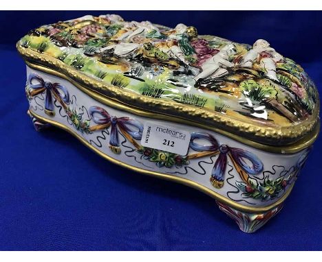 MODERN ITALIAN CERAMIC CASKETthe hinged lid of serpentine outline depicting partially drapped figures feasting in a pastoral 