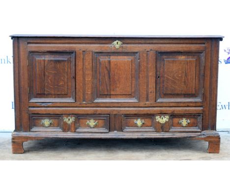 An early 18th century converted oak mule chest with two short drawers under cupboards on bracket feet, the panelled front wit