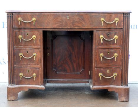 Late 19th/20th century serpentine mahogany and crossbanded kneehole desk, with one long secretarie drawer revealing a  leathe