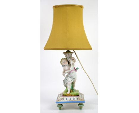 Porcelain figural lamp with putto holding cornucopia, on square base with four feet, anchor mark to base, h36cm (63cm with sh