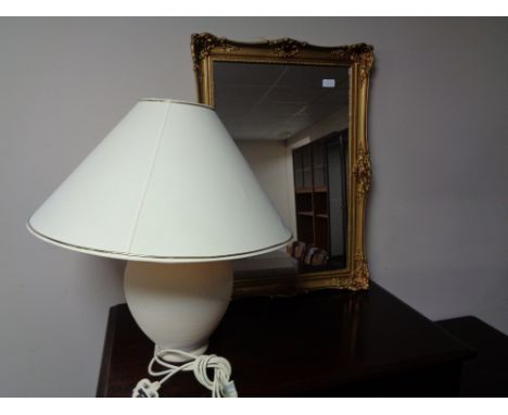 A gilt framed mirror and a pottery table lamp with shade 