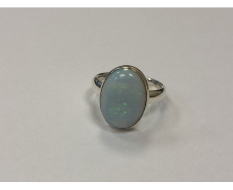 A silver dress ring with opalescent stone, size T