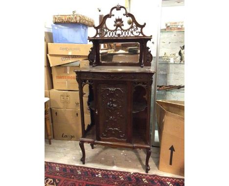 A late Victorian side cabinet, the superstructure with elaborately carved crest above a shelf and mirror, on moulded edged to