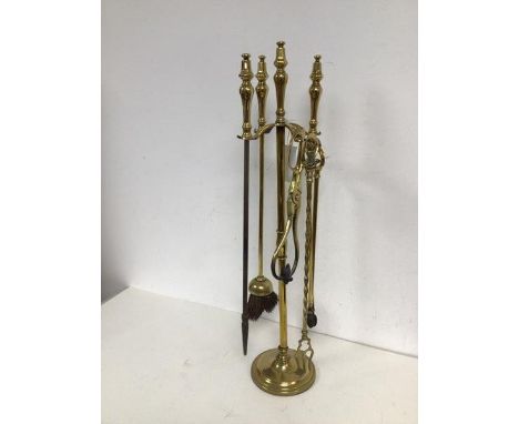 A brass companion set, including a brush, tongs, poker and short tongs and a novelty toasting fork inscribed Junnpel (68cm)