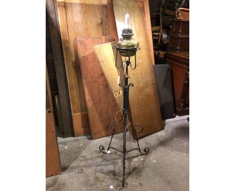 A converted adjustable brass oil lamp on wrought iron tripod base, with copper tap allowing for adjusted height, brass lamp s