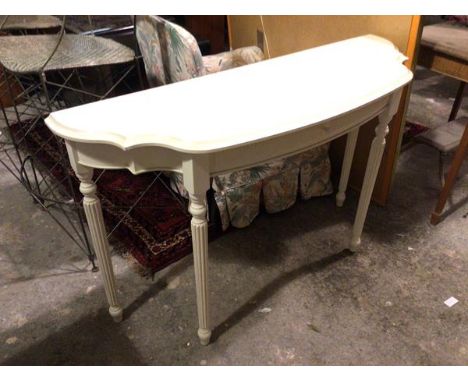 A contemporary white painted console table with undulating moulded top, fitted single frieze drawer, on reeded supports (74cm