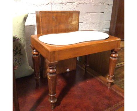 A Victorian mahogany bidet, the interior with undulating ceramic pan, on turned supports