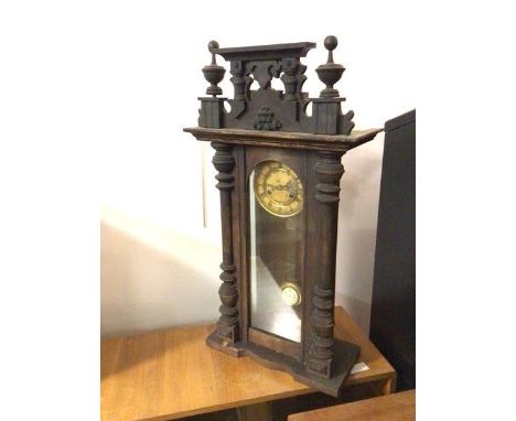 A Victorian wall clock, the architectural surmount above glazed front and sides, enamel dial with roman numerals, pendulum ma