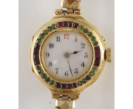 An 18ct yellow gold Swiss ladies gem set wristwatch the white enamel dial with Arabic numerals, the bezzle set peridot and ru