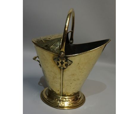 A Victorian brass helmet shaped coal scuttle with swing handle the top embossed with flowers and butterflies, circular foot, 