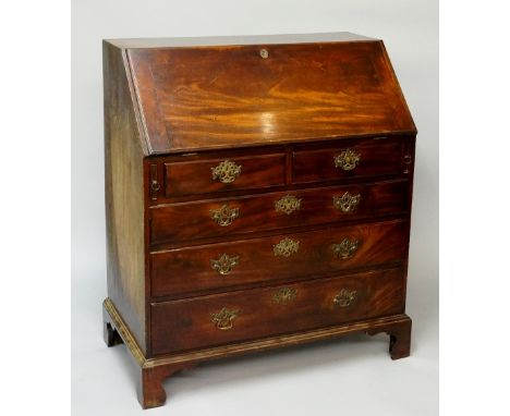 A George III large mahogany bureau the figured fall-flap revealing conventionally fitted interior of pigeon holes and drawers