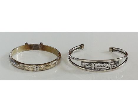 A sterling silver foliate engraved bangle with safety chain, a silver bangle, two wire with hammer textured Greek key centre 