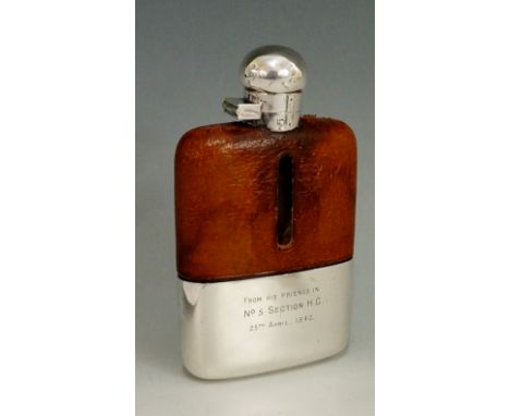 Military interest - A WWII silver plated hip flask, the upper half of the glass body with tan leather cover, the lower half c