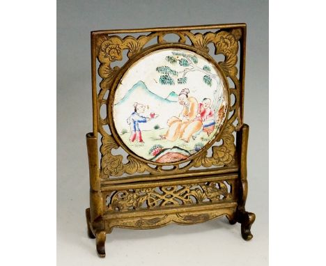 A Cantonese circular enamel miniature table screen, the plaque decorated with figures in a mountainous tree filled landscape,