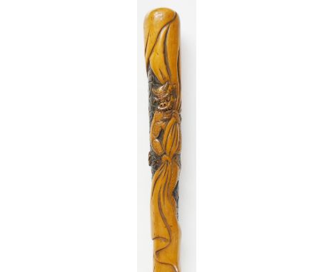 A Japanese stained hardwood walking stick carved with an oni in a loincloth hauling on a sheet, stylised clouds behind, a few