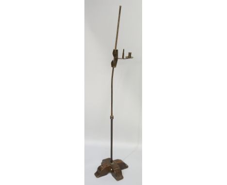An 18th Century steel candle/rush light, the tall stem with cylindrical candle holder with broad drip pan and rush light with