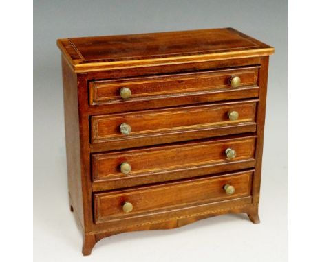 A George III miniature mahogany commode the top string inlaid and crossbanded in rosewood above four cockbeaded graduated dra