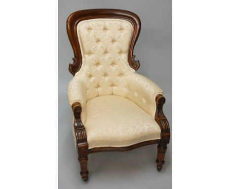 A late Victorian mahogany framed button back nursing chair the moulded back scroll carved fluted arms and turned legs with ce