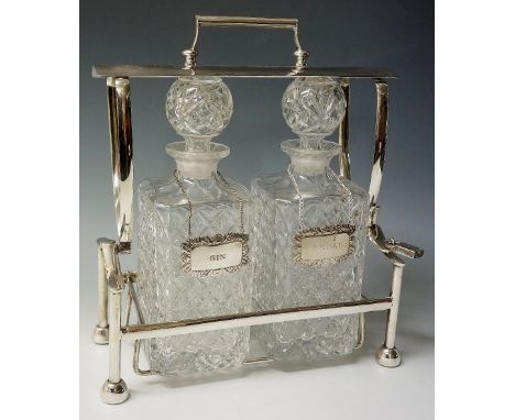 A silver plated tantalus, the two matching moulded glass decanters with diamond quilted bodies and air trap globular stoppers