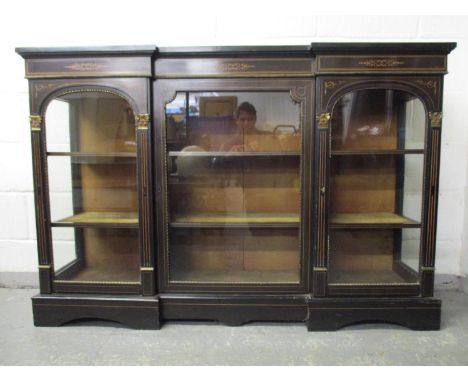 A Victorian boxwood inlaid, ebonized, inverted breakfront credenza with gilt metal mounts and mouldings, three glazed doors e