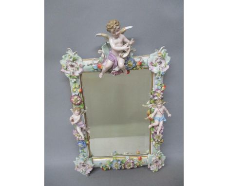 A late 19th century German mirror encrusted with flowers, leaves and three cherubs, with a rectangular bevelled plate, on a w