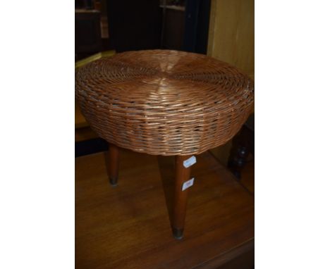 A vintage wickerwork stool on three dansette style legs