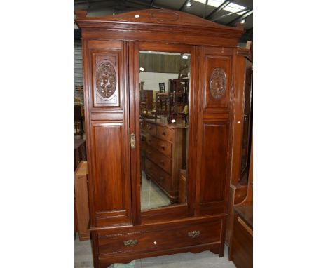 A traditional wardrobe having carved panel doors with under drawer