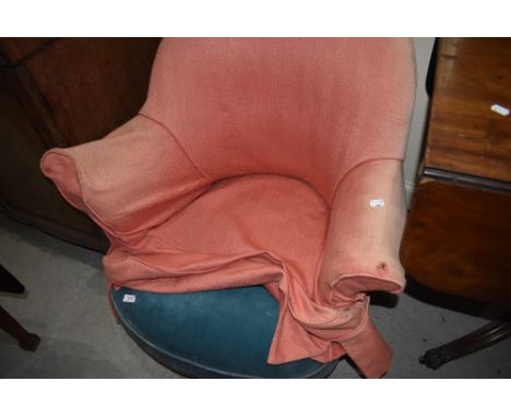 A vintage tub chair having teal dralon upholstery, shepherds castors and loose salmon cover